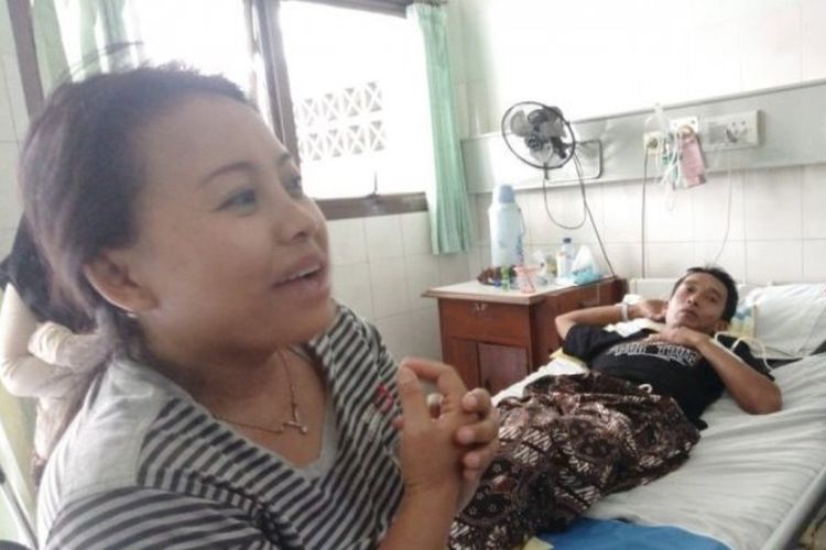 Dwi Indri Astuti (kiri) saat menunggui suaminya, Warsito, yang terbaring lemah usai menghilang selama empat hari di sekitar Kaliadem, Sleman, Yogyakarta.