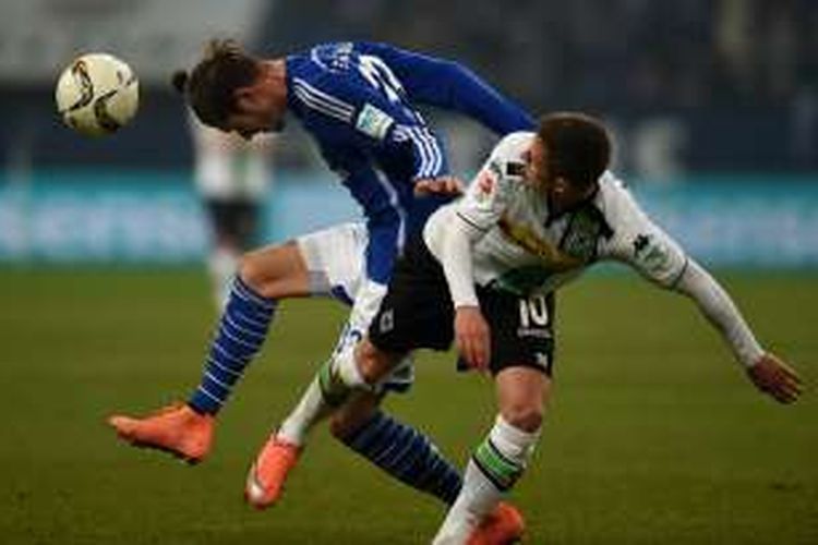 Pemain Schalke, Roman Neustaedter (kiri), berduel dengan pemain Borussia Moenchengladbach, Thorgan Hazard, pada laga Bundesliga di Stadion Veltins Arena, Jumat (18/3/2016) waktu setempat.