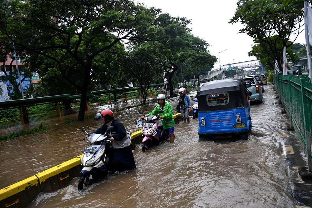 Warga mendorong motornya yang mogok saat melintasi banjir di Jalan Letjen Suprapto, Jakarta Pusat, Sabtu (8/2/2020). Hujan deras yang mengguyur Jakarta sejak Sabtu (8/2) dini hari membuat sejumlah kawasan di Ibu Kota terendam banjir.