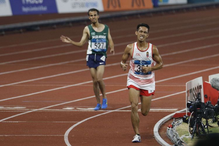 Pelari Indonesia Syamsuddin Massai (no.381) beradu kecepatan dengan pelari lainnya saat babak final Lari 5000 meter Putra Asian Games ke-18 Tahun 2018 di Stadion Utama Gelora Bung Karno Senayan, Jakarta Pusat, Minggu (26/8/2018). Pada pertandingan ini Syamsudin gagal mendapatkan medali dan berada pada posisi ke 8