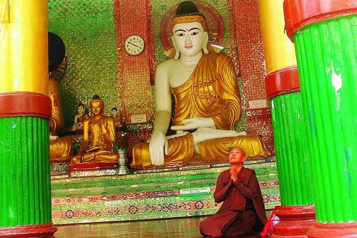 Sorang biksu wanita tengah berdoa di salah satu bagian dari Pagoda Shwedagon, yang ada di pusat Kota Yangon, Myanmar, atau di masa itu kota kuno Okkalapa. Pagoda itu didirikan sekitar 2.500 tahun lalu, dan menyimpan benda keramat berupa delapan helai rambut Sang Buddha Gautama.