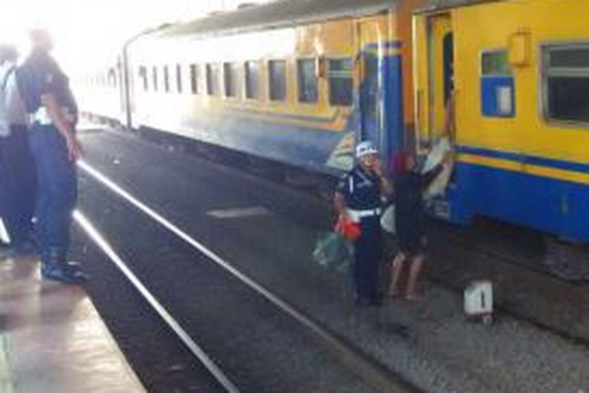 Petugas menertibkan salah satu penumpang kereta yang turun sembarangan ke rel perlintasan saat berhenti di stasiun Palmerah, Sabtu (16/5/2015) pagi.