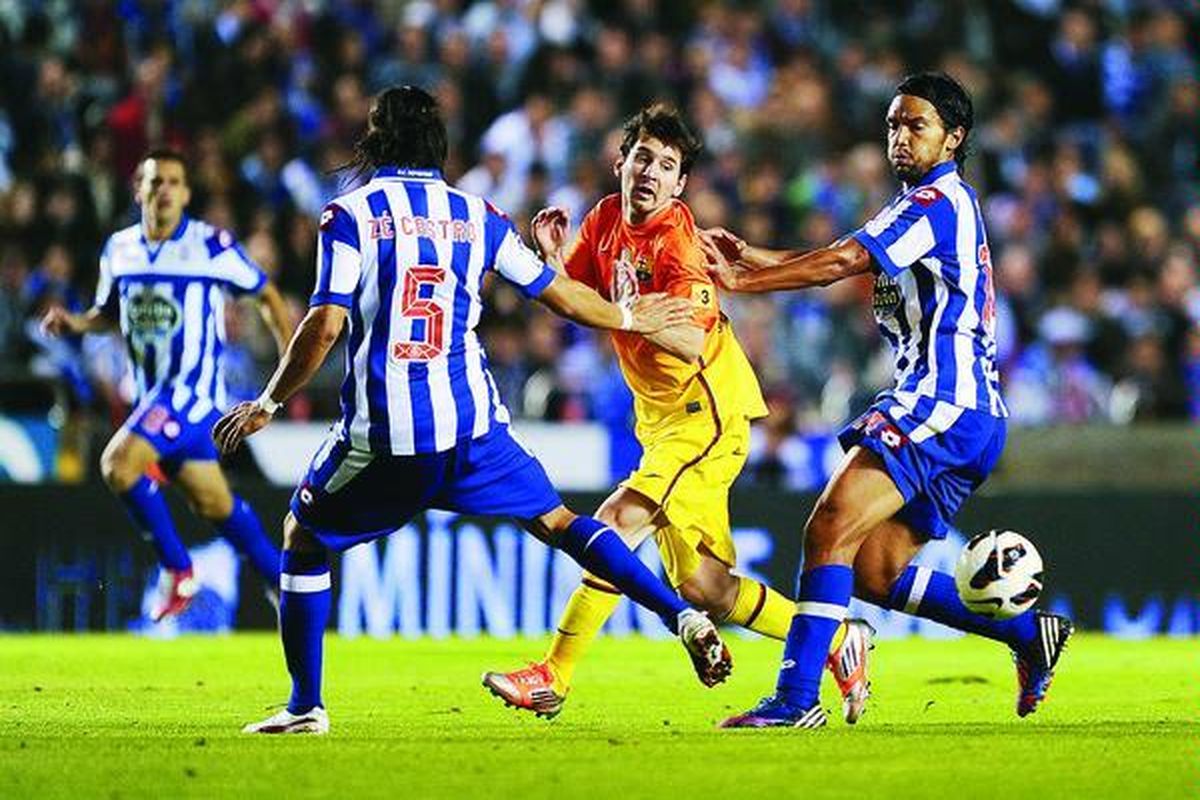 Bintang Barcelona, Lionel Messi (tengah), dikurung para pemain Deportivo La Coruna dalam laga Liga Spanyol yang berlangsung di Stadion  Riazor, Coruna, Sabtu (20/10). Barcelona menang 5-4.