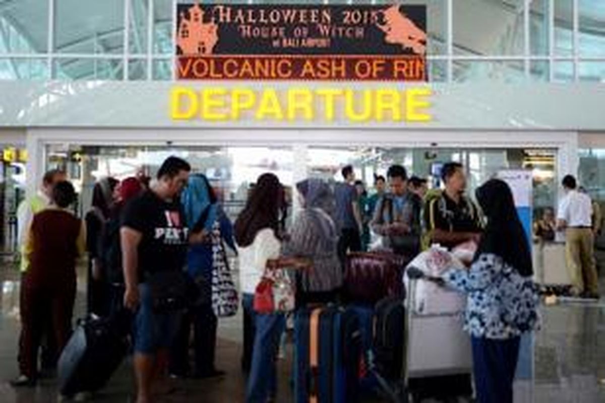 Penumpang menunggu informasi mengenai penerbangan yang ditunda dan dibatalkan di area keberangkatan Bandara Internasional Ngurah Rai, Denpasar, 4 November 2015. Penutupan bandara diperpanjang aktivitas Gunung Barujari yang meningkat. Debu vulkaniknya yang menuju Bali dinilai membahayakan penerbangan.