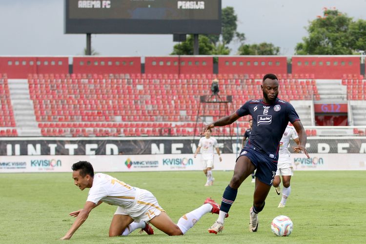 Pemain Arema FC Charles Lokolingoy berhasil melawati pemain Persija Jakarta Rizky Ridho saat laga pekan ke-26 Liga 1 2023-2024 yang berakhir dengan skor 3-2 di Stadion Kapten I Wayan Dipta Gianyar, Senin (26/2/2024) sore.