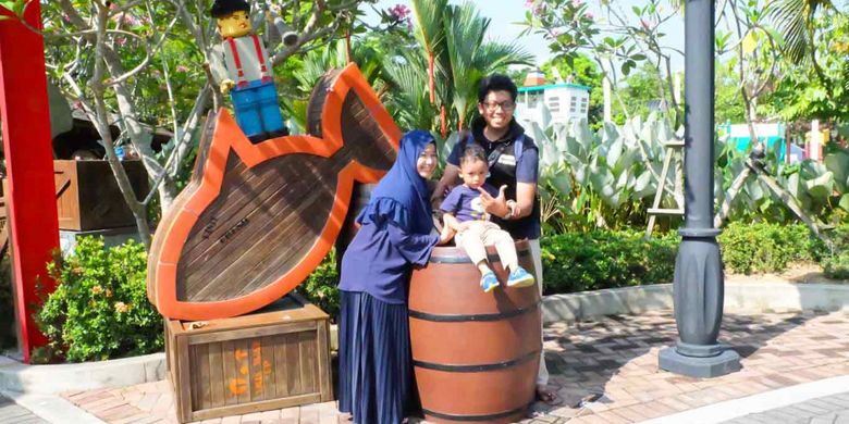 Salah satu pemenang hadiah trip ke Legoland beserta keluarga berpose di depan patung lego, Senin (19/3/2018) lalu.