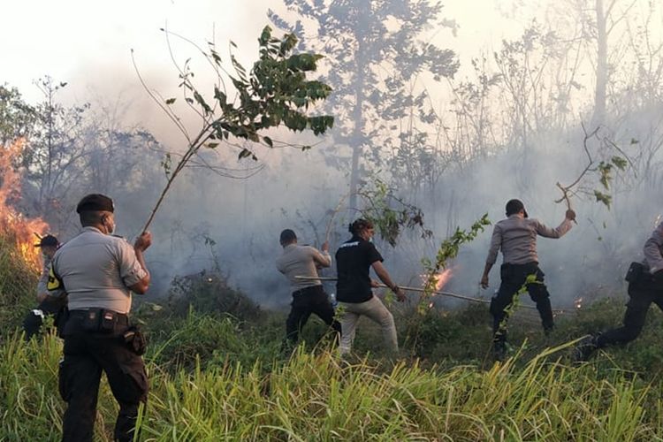 Aparat kepolisian bersama karyawan PT Karlez Petroleoum Bula ltd berusaha memadamkan kebakaran hutan yang semakin dekat dengan gudang tempat penyimpanan bahan [peledak milik perusahan, Selasa petang (17/9/2019)