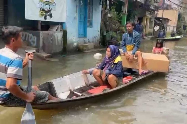 Warga Kampung Bojongasih, Desa Dayeuhkolot, Kwcamatan Dayeuhkolot, Kabupaten Bandung, Jawa Barat menggunakan alat transportasi perahu saat banjir melanda wilayahnya pada Selasa (9/5/2023)