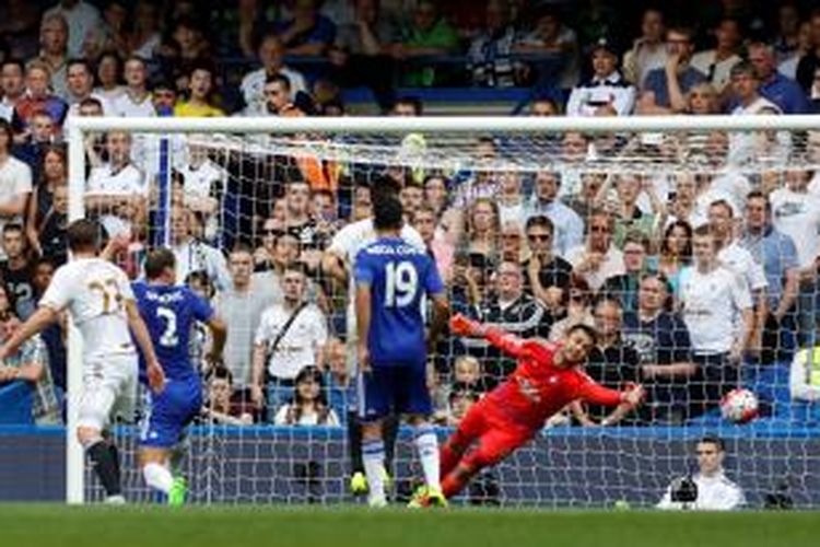 Kiper Swansea City, Lukasz Fabiansky, saat berusaha mengantisipasi bola tendangan gelandang Chelsea, Oscar, yang berujung gol pertama The Blues ke gawang Swansea pada laga perdana Premier League 2015-16 di Stadion Stamford Bridge, Sabtu (8/8/2015).