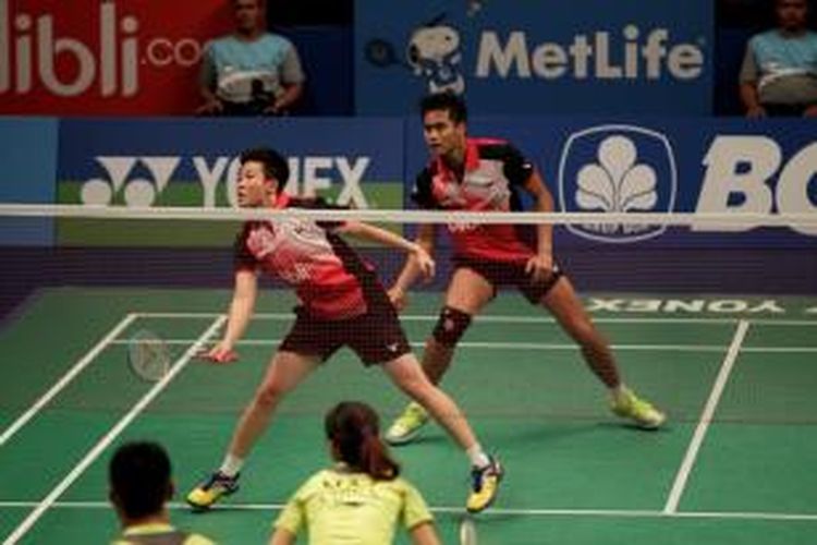 Pasangan ganda campuran Indonesia, Tontowi Ahmad (belakang)/Liliyana Natsir, bertahan dari serangan ganda Tiongkok, Xu Chen/Ma Jian, pada semifinal BCA Indonesia Open Superseries Premier 2014, Sabtu (21/6/2014). Tontowi/Liliyana kalah 21-18, 12-21, 15-21.