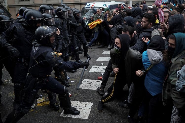 Petugas polisi regional bentrok dengan pendukung pro-kemerdekaan Catalonia yang berusaha mencapai kantor pemerintah Spanyol di Barcelona, ??Minggu (25/3/2018). (AP Photo/Felipe Dana)