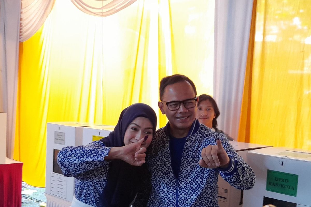 Wali Kota Bogor Bima Arya Sugiarto bersama istri Yane Ardian usai mencoblos di TPS 30, Kelurahan Katulampa, Kecamatan Bogor Timur, Kota Bogor, Jawa Barat, Rabu (14/2/2024).