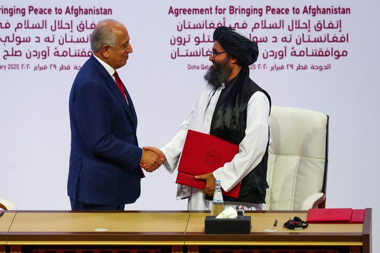 Perjanjian damai antara Amerika Serikat (AS) dan Taliban ditandai dengan jabat tangan antara Zalmay Khalilzad yang merupakan utusan AS (kiri), dan Mullah Abdul Ghani Baradar selaku pemimpin Taliban (kanan). Perjanjian damai ditandatangani di Doha, Qatar, Sabtu (29/2/2020).