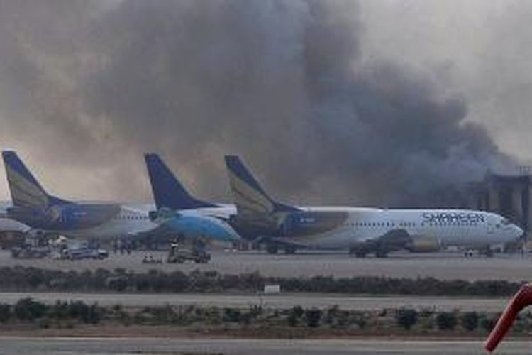 Asap hitam membubung tinggi dari Bandara Internasional Jinnah, Karachi, Pakistan, setelah kelompok bersenjata menyerang bandara tersebut pada Minggu (8/6/2014) malam.