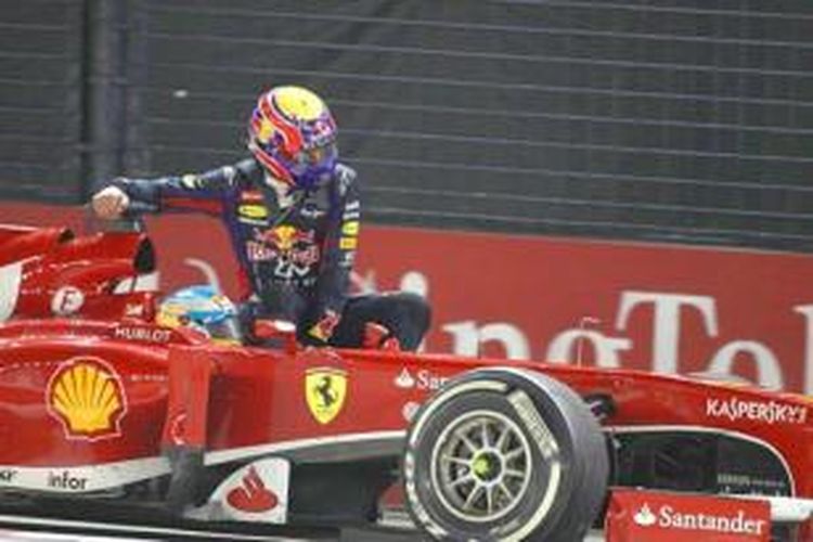 Pebalap Red Bull Racing asal Australia, Mark Webber (atas) menumpang mobil Ferrari yang dikendarai Fernando Alonso, saat menuju pit lane Sirkuit Marina Bay Street, pada akhir GP Singapura, Minggu (22/9/2013).