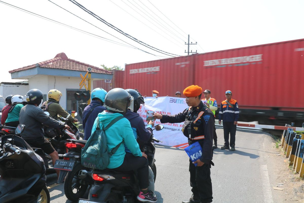 Petugas saat melakukan sosialisasi keselamatan di pelintasan sebidang JPL 361, yang terletak di Jalan Raya Banjar Sari, Kecamatan Cerme, Gresik, Jawa Timur, Jumat (21/7/2023).