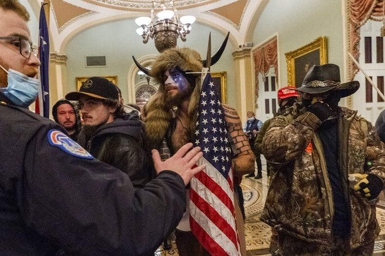 Pendukung Presiden Donald Trump dihadapkan oleh petugas Kepolisian Capitol di luar Kamar Senat di dalam Capitol, Rabu, 6 Januari 2021 di Washington.