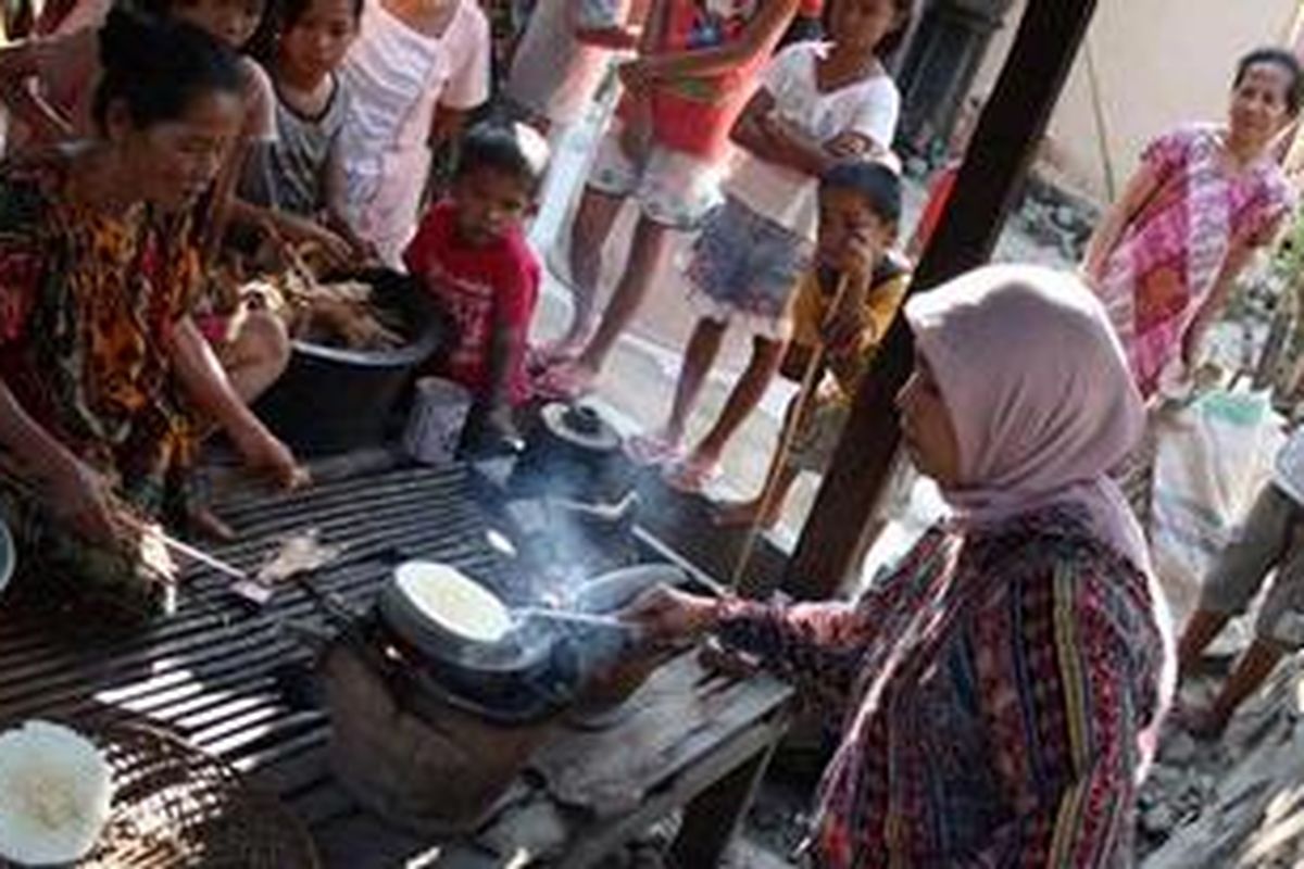 Seorang wisatawan ikut membuat jepa, makanan khas suku Mandar yang terbuat dari singkong. Lokasi pembuatan di Desa Bonde di Kecamatan Pamboang, Majene, Sulawesi Barat.