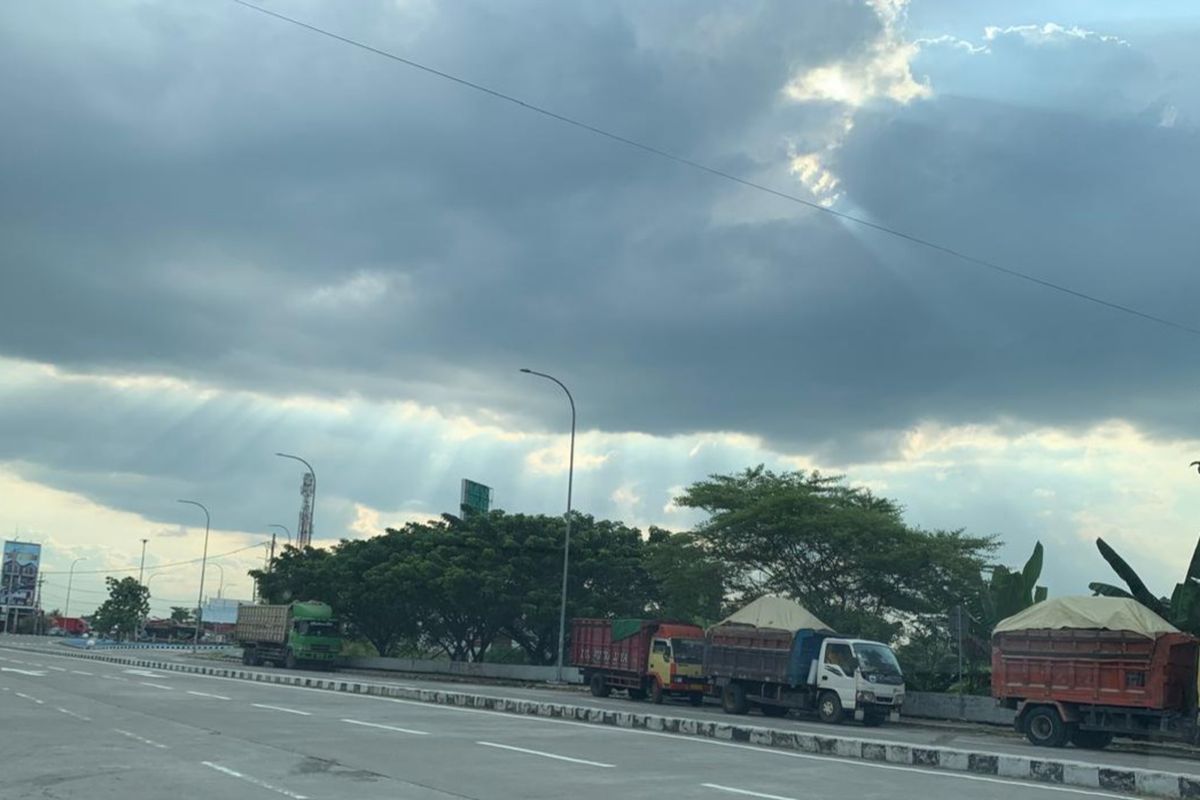 Truk ODOL nekat parkir di bahu jalan meski berada tak jauh dari pos polisi di pintu masuk gerbang tol Madiun.