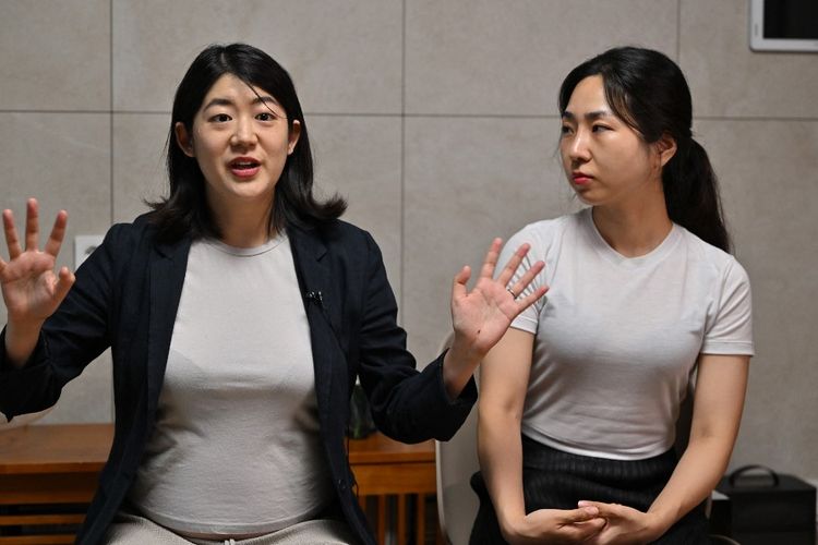 Foto yang diambil pada tanggal 18 Juli 2023 ini menunjukkan pasangan lesbian Korea Selatan, Kim Kyu-jin (Kiri), sedang berbicara dengan istrinya, Kim Sae-yeon (kanan), dalam sebuah wawancara dengan AFP di rumah mereka di Seoul. Korea Selatan telah menghabiskan miliaran dolar untuk kebijakan-kebijakan yang bertujuan untuk meningkatkan angka kelahiran. Namun, ketika Kim Kyu-jin dan istrinya ingin memiliki anak, mereka harus terbang ke Belgia. 