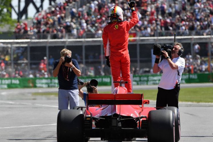 Pebalap Ferrari, Sebastian Vettel, berdiri di atas mobilnya untuk merayakan keberhasilan meraih pole position pada kualifikasi F1 GP Kanada di Sirkuit Gilles-Villeneuve, Montreal, Kanada, Minggu (10/6/2018).
