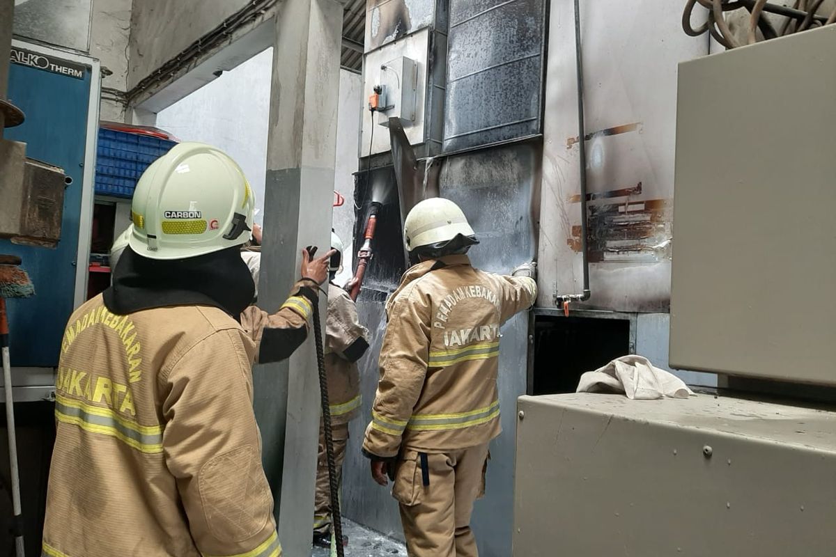 Petugas melakukan upaya pendinginan pada mesin oven yang sebelumnya terbakar di di bengkel mobil di Jalan Hadiah, Jelambar, Grogol Petamburan, Jakarta Barat, terbakar pada Sabtu (1/10/2022). 