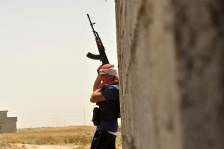 Seorang warga suku Turkmen, Irak mengangkat senjatanya saat berjaga di desa Turklan, 15 kilometer dari kota Kirkuk yang kini dikuasai kelompok Kurdi di tengah kosongnya kendali pasukan pemerintah.