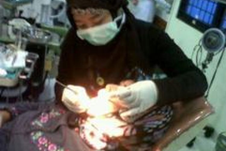 Dokter gigi yang berpraktik di Rumah Sakit Umum Pusat Fatmawati Jakarta Selatan menggunakan jas hitam saat berpraktik menangani pasien