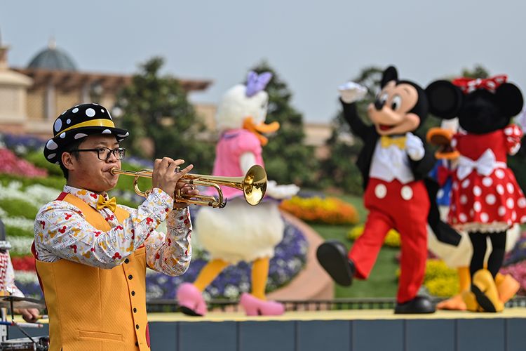 Penampil meniup terompet saat memberikan hiburan pada pengunjung saat pembukaan kembali taman hiburan Disneyland, Shanghai, China, Senin (11/5/2020). Shanghai Disneyland resmi kembali dibuka setelah ditutup selama 4 bulan akibat pandemi virus corona.