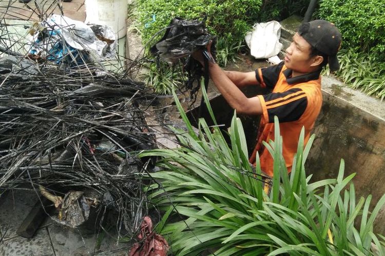 Pasukan oranye atau petugas Penanganan Prasarana dan Sarana Umum (PPSU) Kelurahan Kuningan Barat menemukan kulit kabel di saluran air sebabkan Jalan Gatot Subroto tergenang pada Kamis (2/3/2017) petang. 