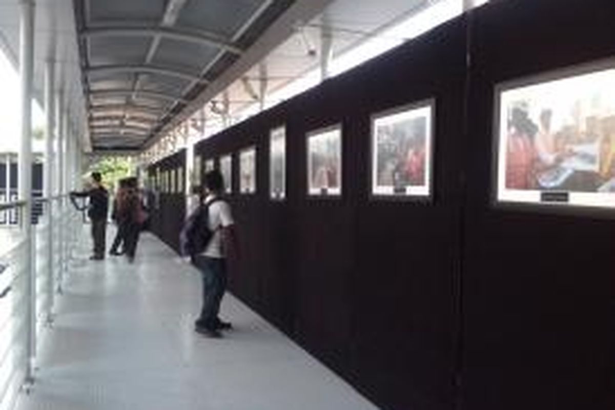 Pejalan kaki melihat pameran foto di jembatan penyeberangan orang di kawasan Bundaran Hotel Indonesia, Sabtu (1/11/2014).