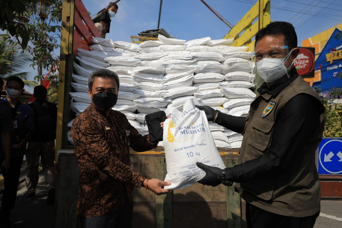 Wali Kota Madiun Maidi menunjukkan beras medium dari Kemensos yang diberikan kepada warga terdampak Covid-19 di depan Balai Kota Madiun, Jumat (6/8/2021).