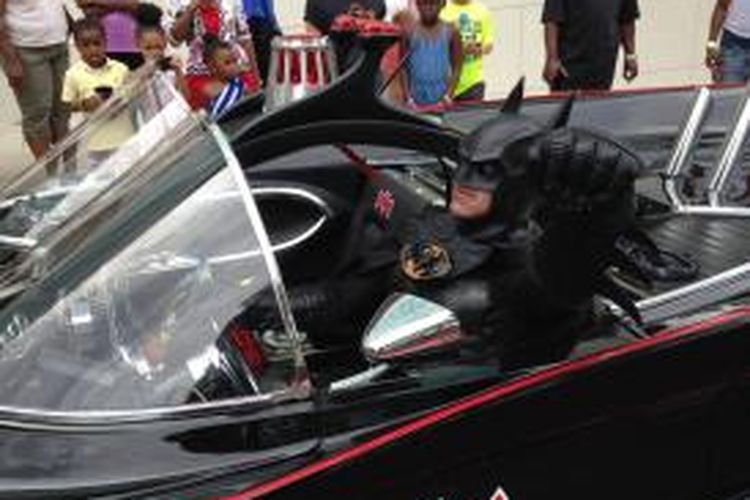 Lenny Robinson mengenakan kostum Batman dan mengendarai mobil yang dimodifikasi menjadi Batmobile.