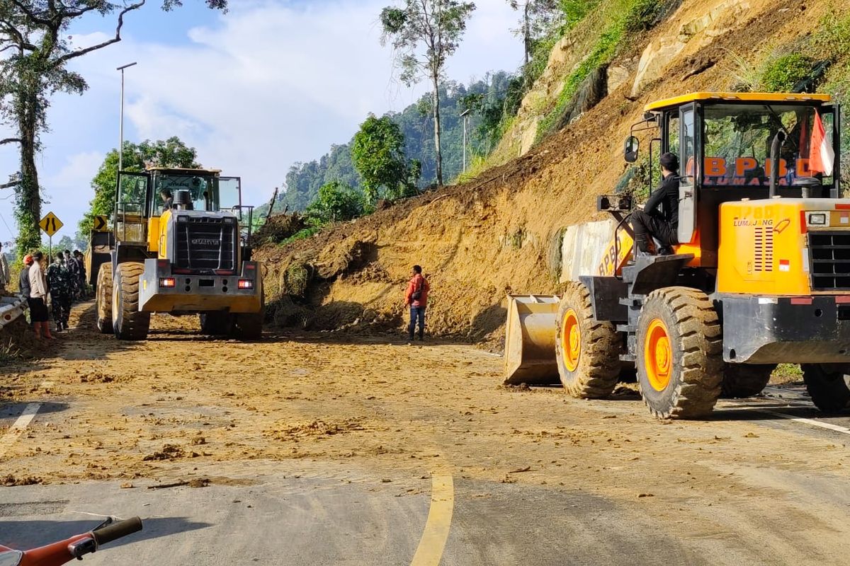 Petugas membersihkan material longsor yang menutupi jalur Piket Nol Lumajang, Selasa (13/5/2025).
