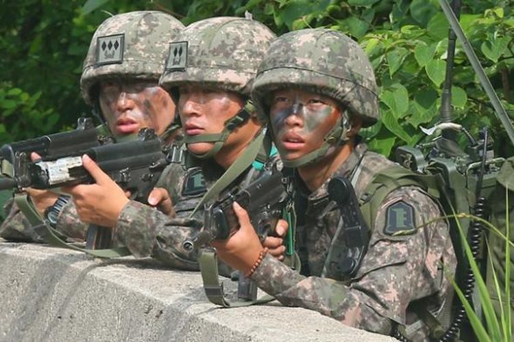 Para prajurit Korea Selatan ini berlindung di balik pembatas jalan saat mengepung tersangka pelaku penembakan lima tentara di sebuah kawasan hutan di wilayah timur negeri itu. Setelah dikepung selama 24 jam, pelaku penembakan bisa diringkus.