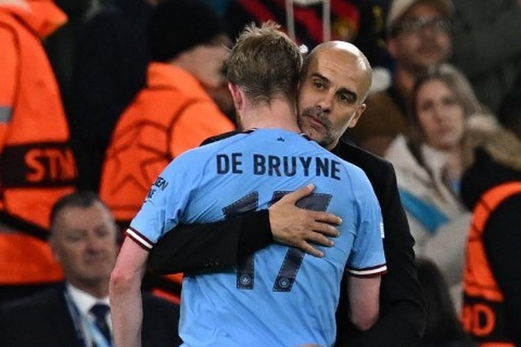 Pelatih Man City, Pep Guardiola, memeluk Kevin De Bruyne usai ditarik keluar dalam pertandingan melawan Real Madrid pada leg kedua semifinal Liga Champions 2022-2023. Laga Man City vs Madrid bergulir di Stadion Etihad pada 17 Mei 2023. (Foto oleh Paul ELLIS / AFP)