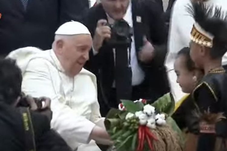 Paus Fransiskus menerima bunga tangan dari dua anak Indonesia usai tiba di Tanah Air, Selasa (3/9/2024).