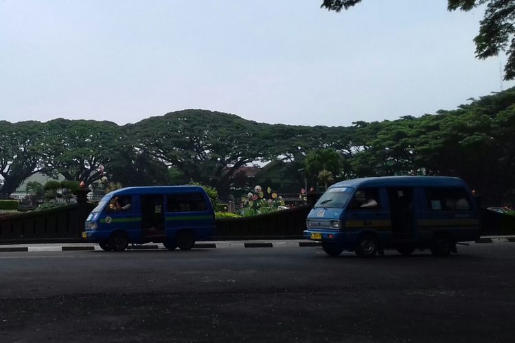 Dua unit angkot melintas di Bundaran Tugu Kota Malang, Jumat (4/1/2019)
