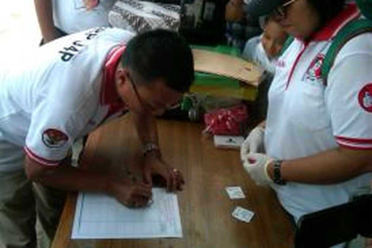Seorang warga mendaftar untuk aksi cap jempol darah dalam rangka mendukung bakal calon presiden dari PDI Perjuangan Joko Widodo di Simpang Lima, Semper Barat, Jakarta Utara, Minggu (18/5/2014).