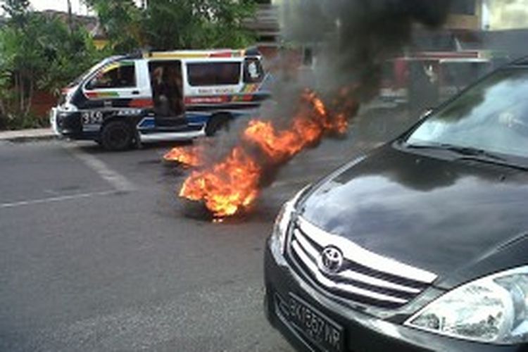 Aksi mahasiswa depan kampus FKIP HKBP Nomensen Pematangsiantar membakar ban di Jalan Asahan, Pematangsiantar, Sumatera Utara, Kamis (20/6/2013).