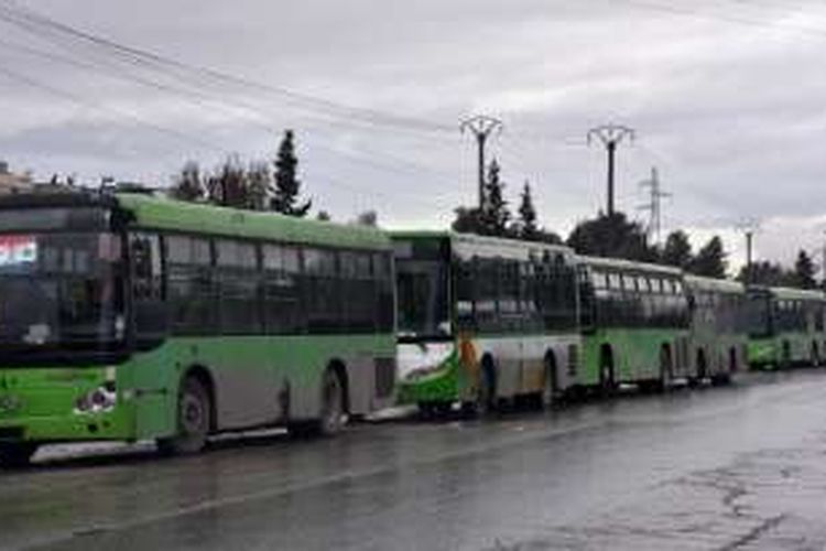 Sederet bus berwarna hijau menunggu di salah satu sudut kota Aleppo untuk digunakan sebagai sarana evakuasi warga sipil dari wilayah timur kota itu.