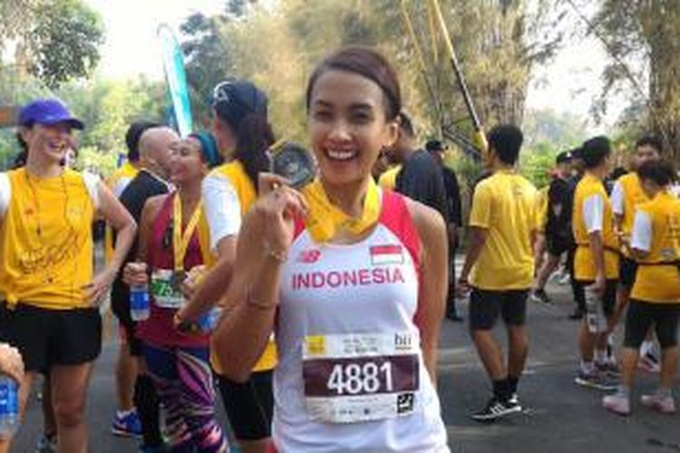 Putri Indonesia 2002, Melanie Putria, memamerkan medali yang didapat setelah menyelesaikan balapan half marathon BII Maybank Bali Marathon di Bali Safari and Marine Park, MInggu (30/8/2015).