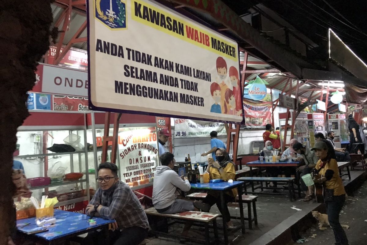 Spanduk Kawasan Wajib Masker di kuliner Bubur Ayam Barito, Kebayoran Baru, Jakarta, Selasa (7/7/2020) malam.
