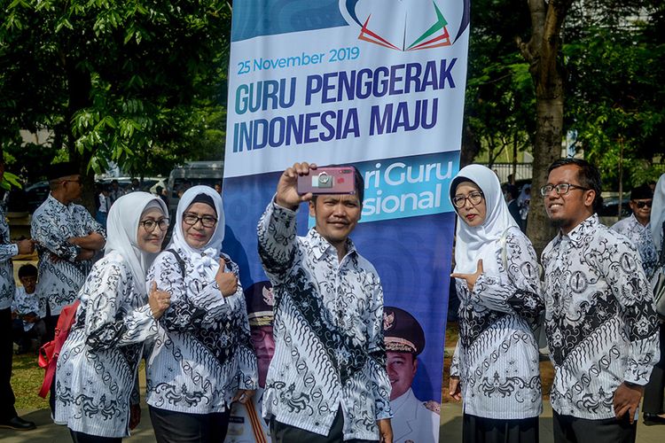 Sejumlah guru berswafoto usai mengikuti upacara dalam rangka peringatan  Hari Guru Nasional yang di pimpin oleh Gubernur Jawa Barat, Ridwan Kamil di Lapangan Gasibu, Bandung, Jawa Barat, Senin (24/11/2019). Pada momentum peringatan Hari Guru Nasional tahun ini, Ridwan Kamil berjanji siswa-siswi yang belajar di Jabar tidak lagi harus membayar uang iuran sekolah (SPP) pada 2020.