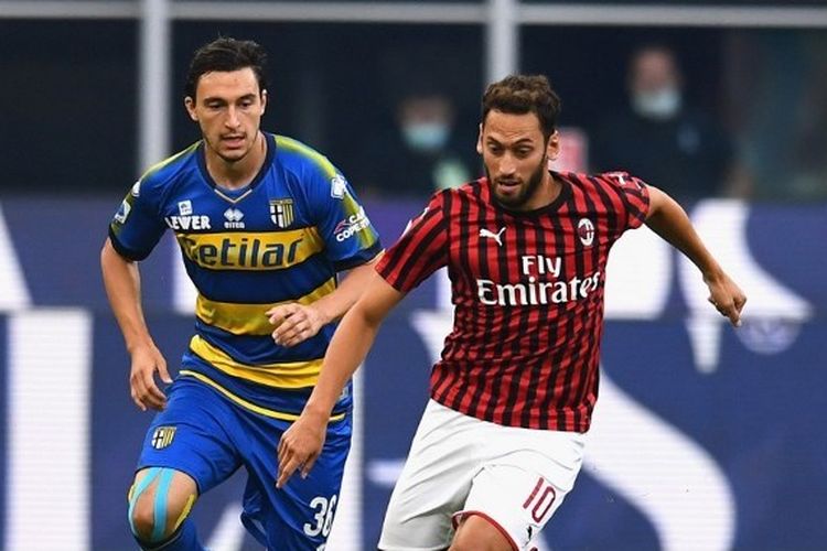 Matteo Darmian berebut bola dengan Hakan Calhanoglu dalam laga AC Milan vs Parma pada lanjutan pekan ke-33 Liga Italia 2019-2020 yang dilangsungkan di Stadion San Siro, Kamis (16/7/2020) dini hari WIB.