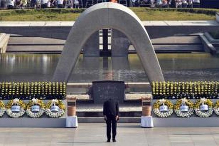 Perdana Menteri Jepang Shinzo Abe membungkuk, sebagai penghormatan, di depan tugu peringatan peristiwa serangan bom atom Hiroshima, di Hiroshima Peace Memorial Park, barat Jepang, 6 Agustus 2015. Puluhan ribu orang hadir dalam peringatan 70 tahun peristiwa serangan bom atom tersebut.
