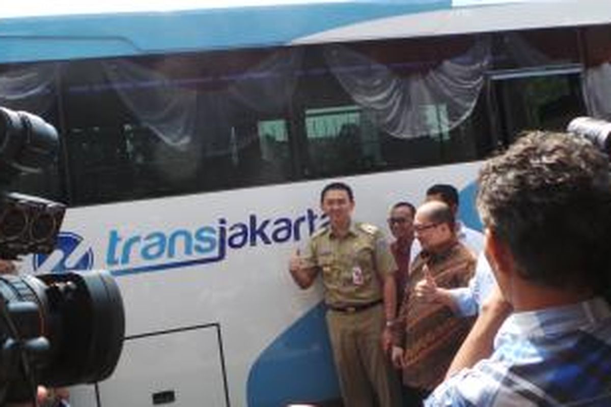 Gubernur DKI Jakrta Basuki Tjahaja Purnama saat berfoto bersama Direktur Utama PT Transjakarta Antonius NSa Kosasih di depan bus Kopaja yang terintegrasi transjakarta bermerek Toyota, di Balai Kota, Rabu (24/6/2015). 