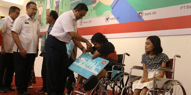 Terlihat salah satu peyandang disabilitas mencium tangan Gubernur DKI Jakarta Anies Baswedan karena mendapatkan Kartu Penyandang Disabilitas Jakarta (KPDJ).