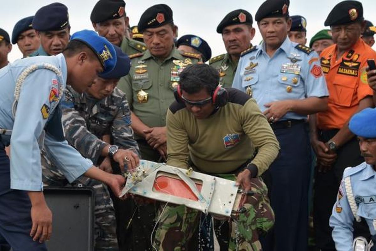 Para petugas memasukkan FDR (Flight Data Recorder) AirAsia QZ8501 ke dalam tas pengaman di Pangkalan Bun, Senin (12/1/2015).