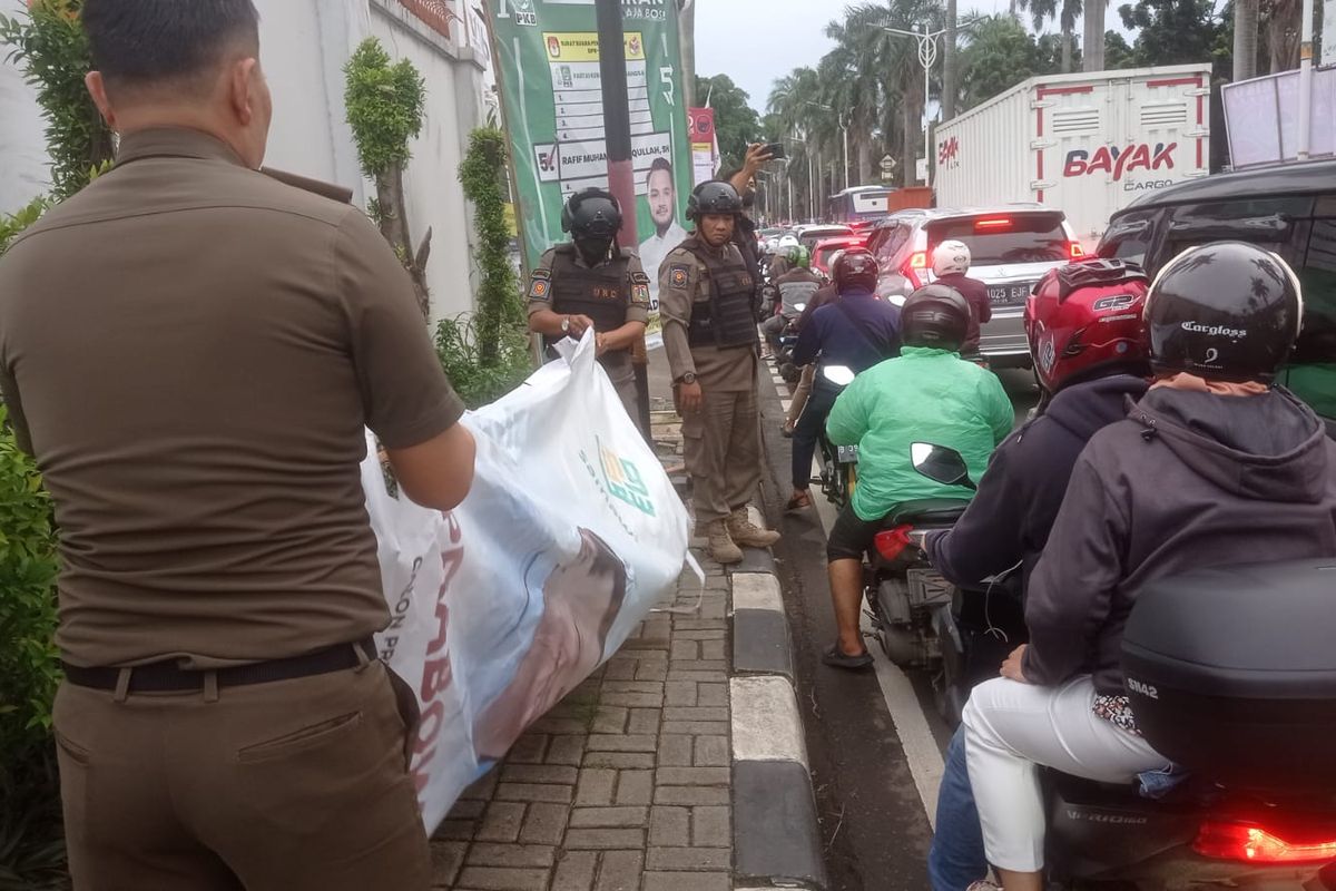 Satpol PP Jakarta Selatan saat menertibkan alat peraga kampanye (APK) yang roboh di Jalan Metro Pondok Indah, Kebayoran Lama, Jakarta Selatan, Selasa (6/2/2024).